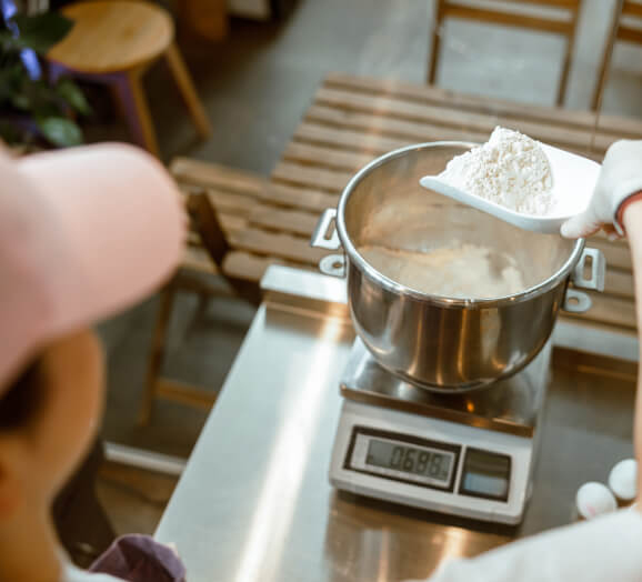 Chef weighing flour on commercial digital food scale
