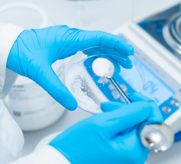 Lab technician measuring powder on precision digital lab scale