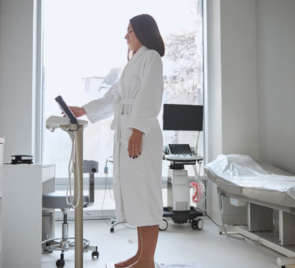 Patient using hospital-grade digital medical scale for body analysis