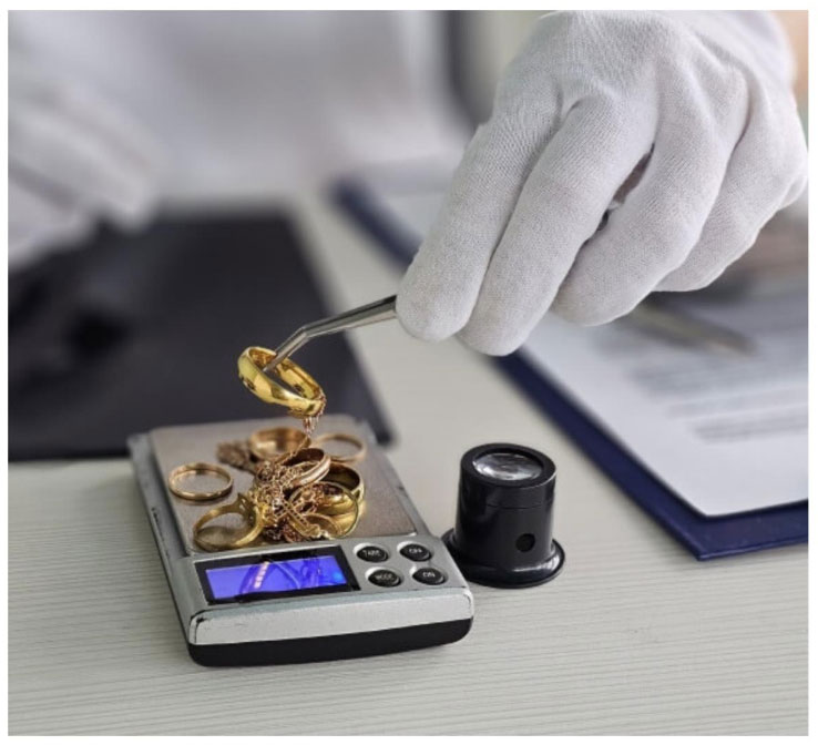 Close-up of a digital gold scale displaying weight in grams with a small gold chain on the platform.